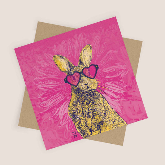 Illustrated bunny wearing heart-shaped sunglasses on a pink background