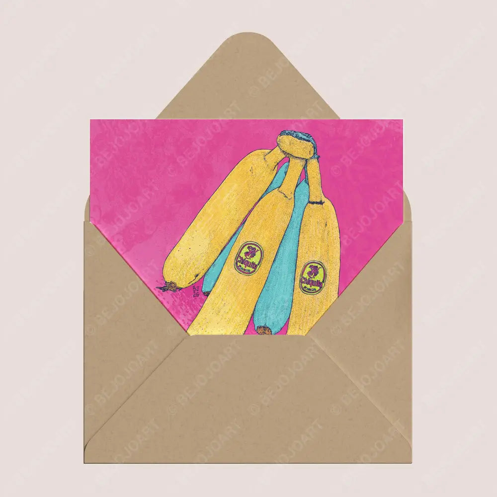 A square greeting card with a kraft paper envelope behind it. The card features a colorful illustration of three yellow bananas with blue and purple details on a bright pink background.
